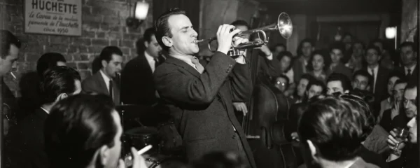 Boris Vian jouant de la trompette dans un club de jazz enfumé de Saint-Germain-des-Prés, photographie en noir et blanc des années 1950 prise sur le vif
